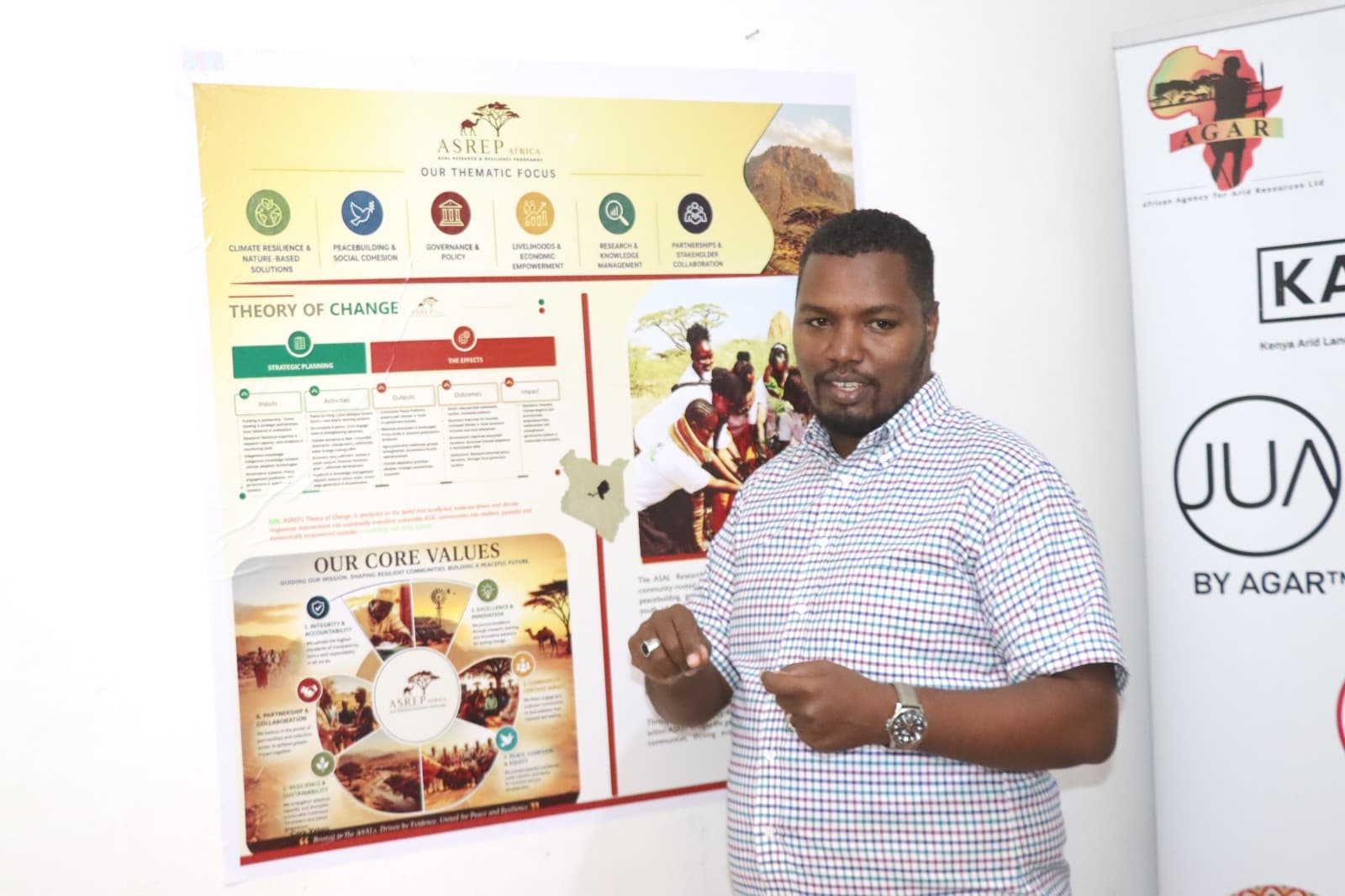 ASREP Africa Executive Director Dida Fayo presenting near the ASREP thematic-focus poster at the MOU signing ceremony
